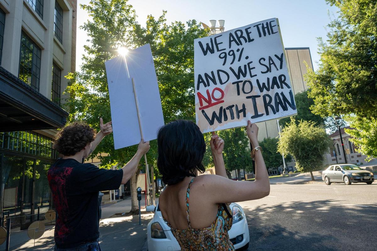 Diana Zabihian holds a sign protesting against war in Iran on the corner of 16th and J streets in Sacramento on Wednesday. She and her family are from Iran, and she is attending Sacramento State, where her father is a faculty member.
