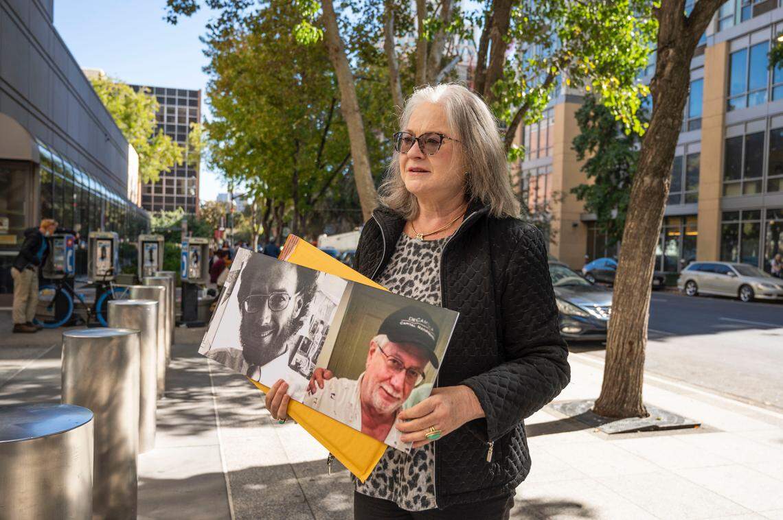 East Sacramento resident Melinda Willey holds portraits Monday, Oct. 24, 2022, of former Capital Public Radio executive Charles Starzynski, who was fatally shot last week near the Sutter Lawn Tennis Club, outside the Sacramento County Main Jail before the arraignment of shooting suspect DeSean Leon Brasser Jr. Willey said she was a friend and associate of Starzynski. “He was a stellar man,” she said.