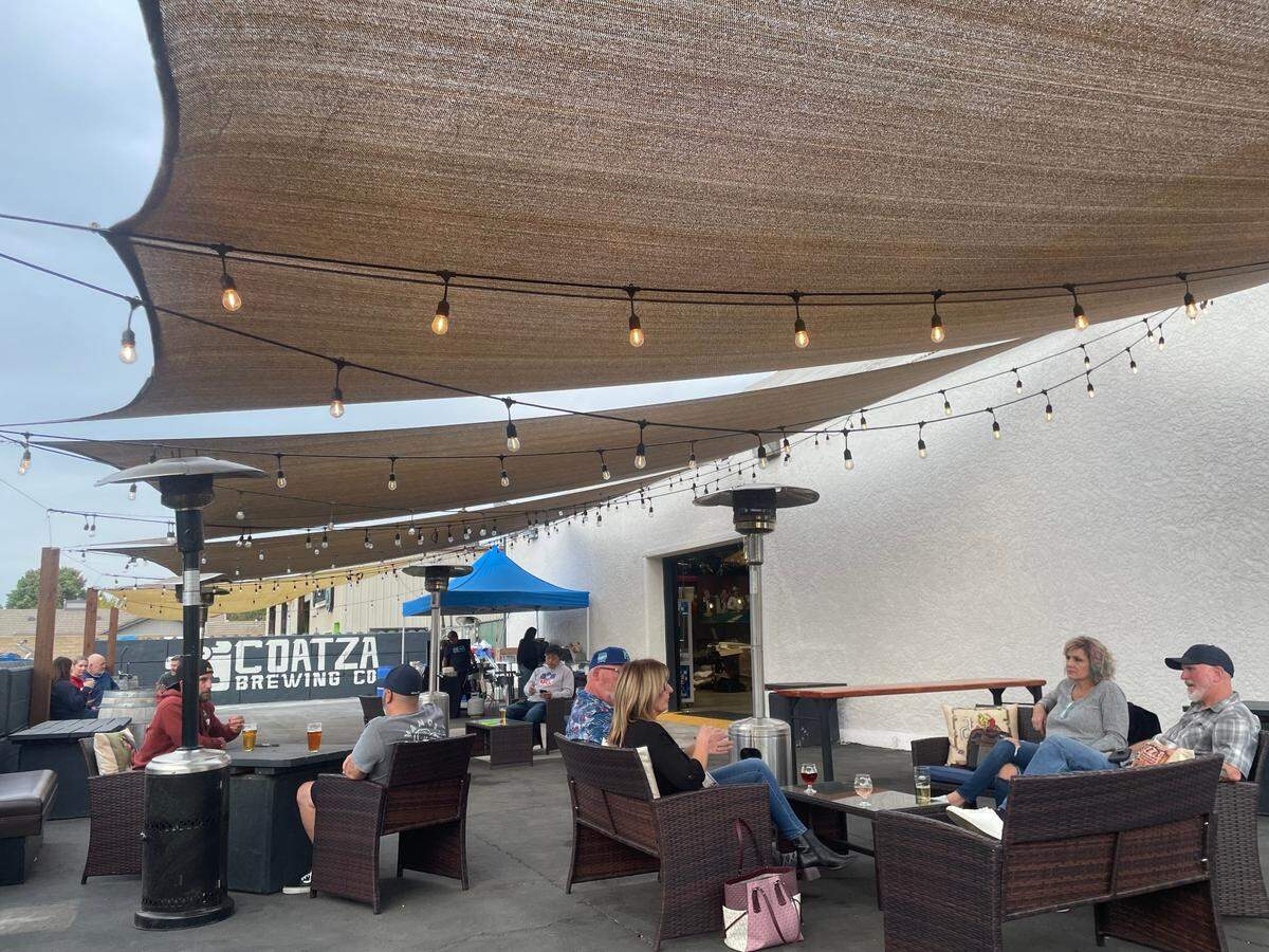 Patrons hang out on the patio at Coatza Brewery, located at 9251 Elk Grove Blvd. in Elk Grove’s Old Town area, on Thursday.