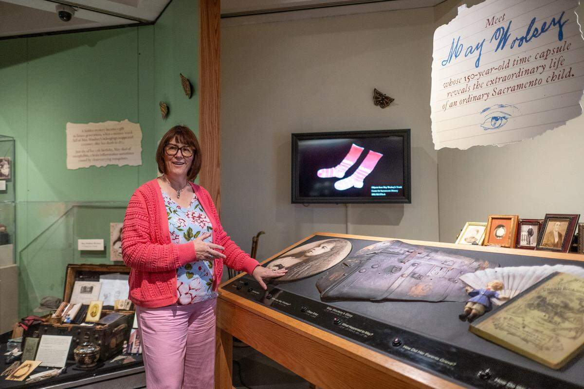 Delta Mello, executive director of the Sacramento History Museum, demonstrates a tactile interactive exhibit in Sacramento that plays audio about May Woolsey, who died in 1879 at age 12, on Friday, March 27, 2026. She hopes to expand the exhibit as an educational tool to help students learn about life and history during that period.