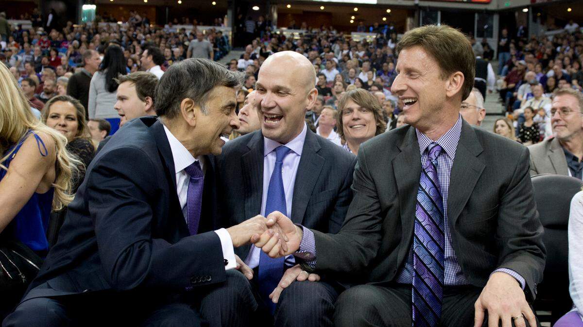 Sacramento Kings majority owner Vivek Ranadivé, left, shakes hands with minority owner Mark Mastrov in front of General Manager Chris Granger at a game at Sleep Train Arena in 2014.