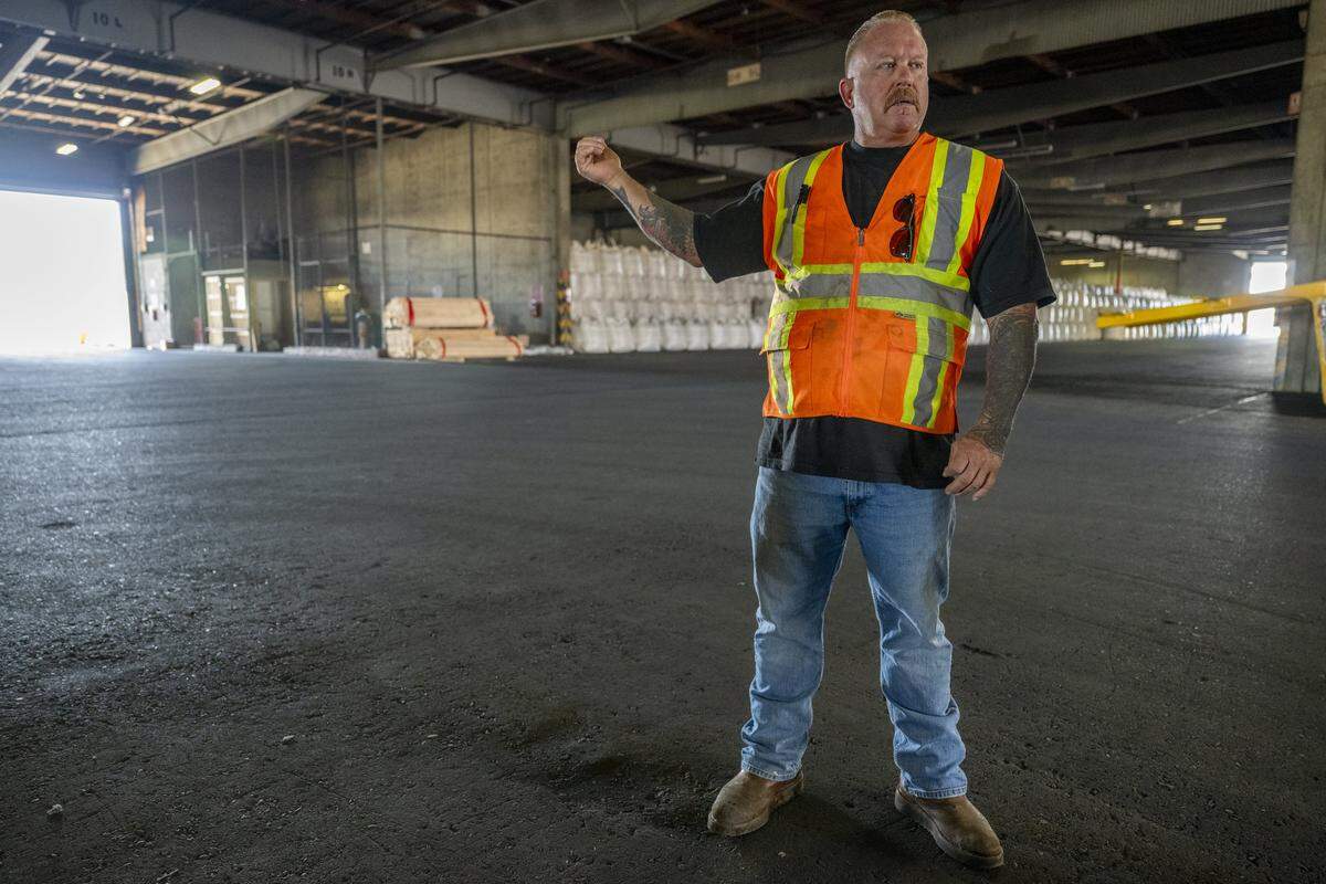 Tim Campbell, president of International Longshore and Warehouse Union Local 18, speaks with a reporter inside of a rice shed while providing a tour of the Port of West Sacramento on Thursday, July 31, 2025.