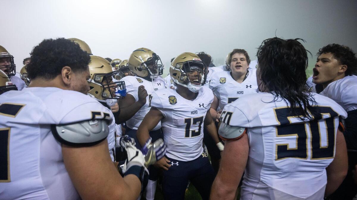 Elk Grove running back Zeke Burnett (13), center, celebrates with teammates after their 52-48 win over Vacaville at their high school football playoff game Friday, Nov. 12, 2021, in Vacaville.