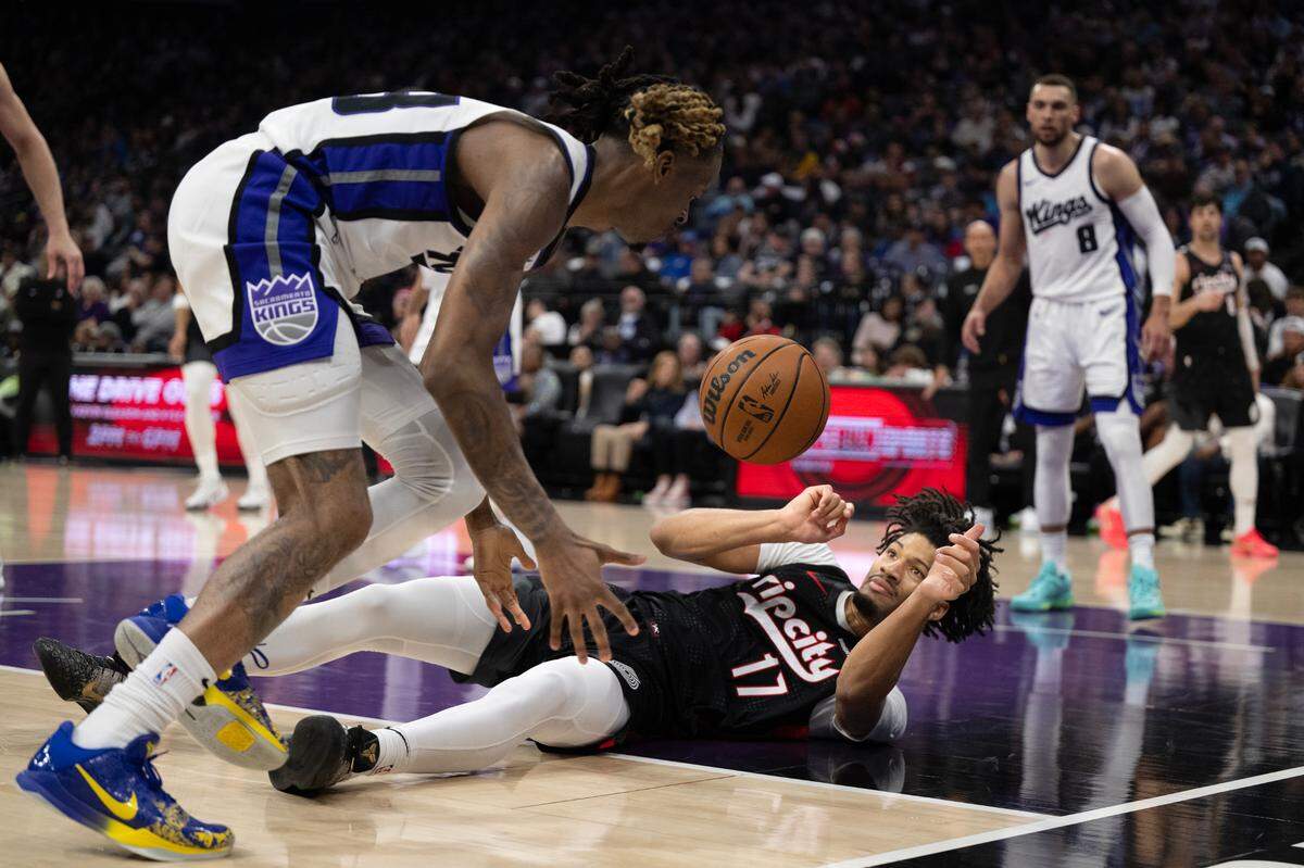 Sacramento Kings guard Keon Ellis (23) picks up a loose ball in front of Portland Trail Blazers guard Shaedon Sharpe (17) in the first half on Thursday, March 27, 2025 at Golden 1 Center.
