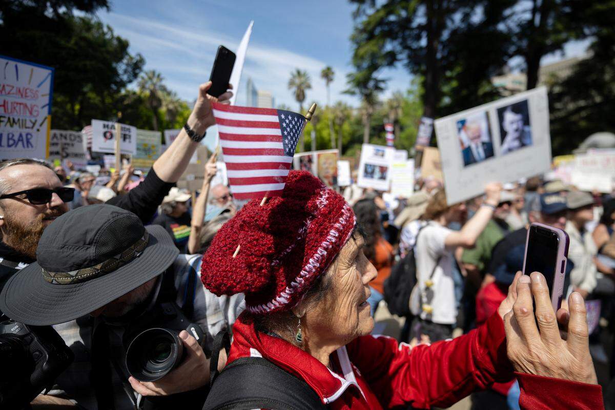Maria, 83, photographs speeches during the 50501 protest against the Trump administration at the state Capitol on Saturday.