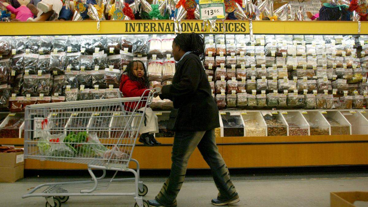 Fresno, CA 12/19/03 (biz dlw foods co tamale pinatas) Tanidra Hughes and her daughter Aujah Lee, 7, past by an aisle of international spices and pinatas at the Foods Co grocery store on Shaw Avenue on Friday afternoon December 19, 2003. (Darrell Wong/The Fresno Bee)