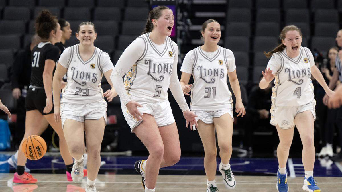 The Faith Christian Lions' Lauren Harris (5) celebrates the victory with Kimber Cunningham (23), Moriah Ely (31), and Ella Haeberle (4) following the 51-37 victory over the Palisades Dolphins in the CIF State Division IV girls basketball championship Friday, March 14 at Golden 1 Center.