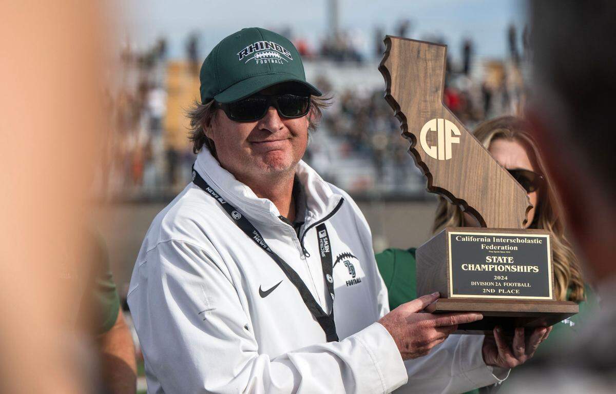 Twelve Bridges Raging Rhinos coach Chris Bean holds the second-place trophy after his team’s loss to the Palos Verdes Sea Kings in the CIF State Division 2-A championship game at Saddleback College in Mission Viejo on Dec. 14. Bean is The Bee’s Coach of the Year.