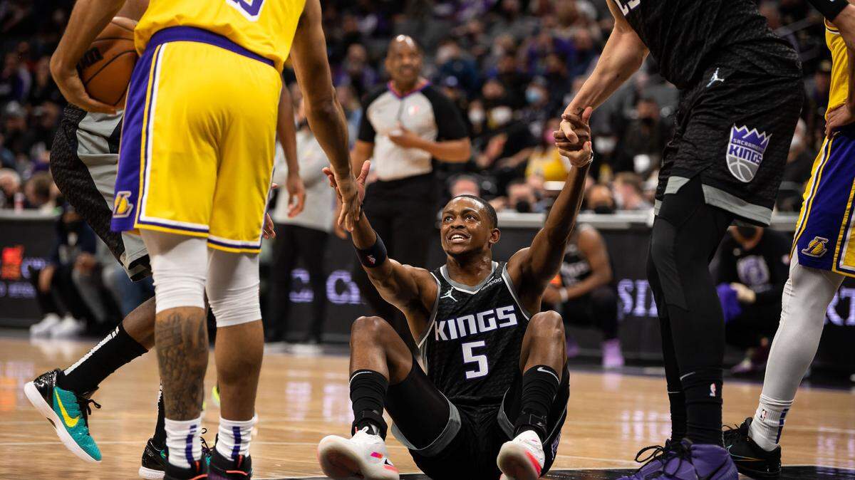 Sacramento Kings guard De’Aaron Fox (5) gets a hand up from Los Angeles Lakers guard Talen Horton-Tucker (5), after fouling him, and Sacramento Kings center Alex Len (25) during the first half of the NBA basketball game Wednesday, Jan. 12, 2022, at Golden 1 Center in Sacramento.