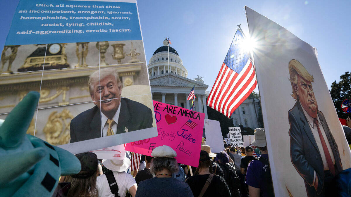 Demonstrators hold signs during the "No Kings" protest at the state Capitol in Sacramento on Saturday, Oct. 18, 2025.