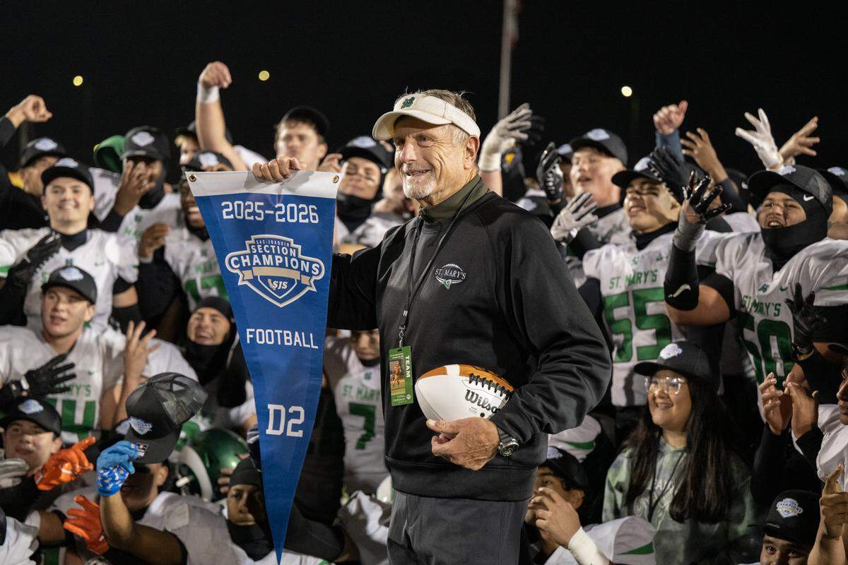 St. Mary’s Rams head coach Tony Franks holds up the championship banner following the CIF Sac-Joaquin Section Division lI football championship game against the Granite Bay Grizzlies on Saturday at Hughes Stadium in Sacramento.