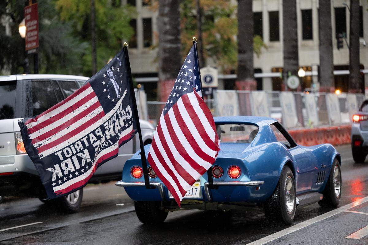 A corvette flying the American flag and a flag honoring slain conservative activist Charlie Kirk is driven Tuesday on 10th Street near the state Capitol in Sacramento during an event marking Kirk’s birthday.