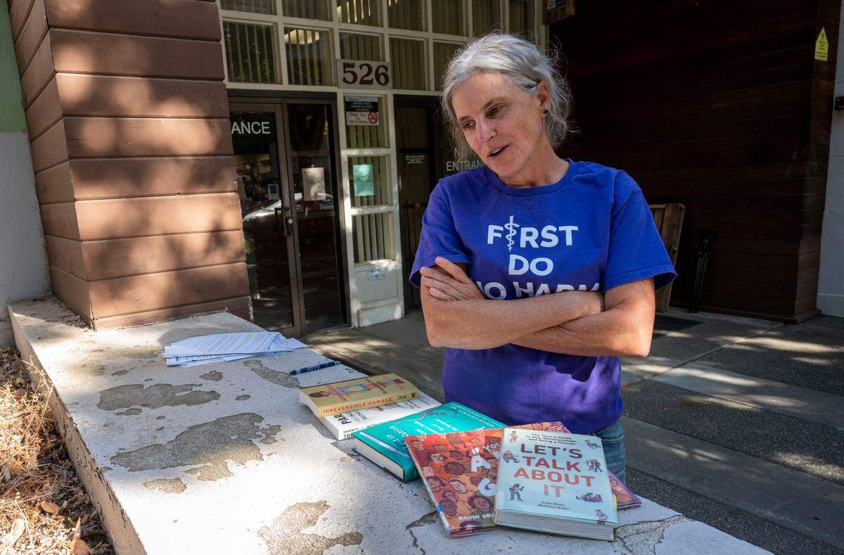 Yolo County Moms for Liberty chapter chair Beth Bourne stands outside a meeting at the Davis Joint Unified School District in September with a display of books from the Davis Library she felt were inappropriate for children.
