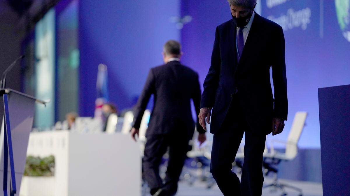 John Kerry, right, U.S. special envoy for climate, walks off the stage after speaking with Alok Sharma, left, president of COP26, at the climate summit in Glasgow.