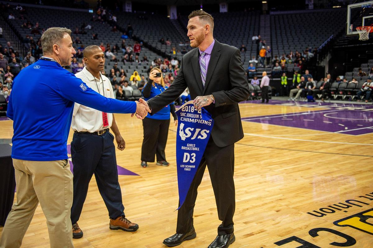 Bradshaw Christian High School girls basketball head coach, Mike Ruble, accepts the blue banner after his team wins the Sac-Joaquin Section Girls Basketball Championship - Division III tournament at Golden 1 Center, Saturday, February 23, 2019.