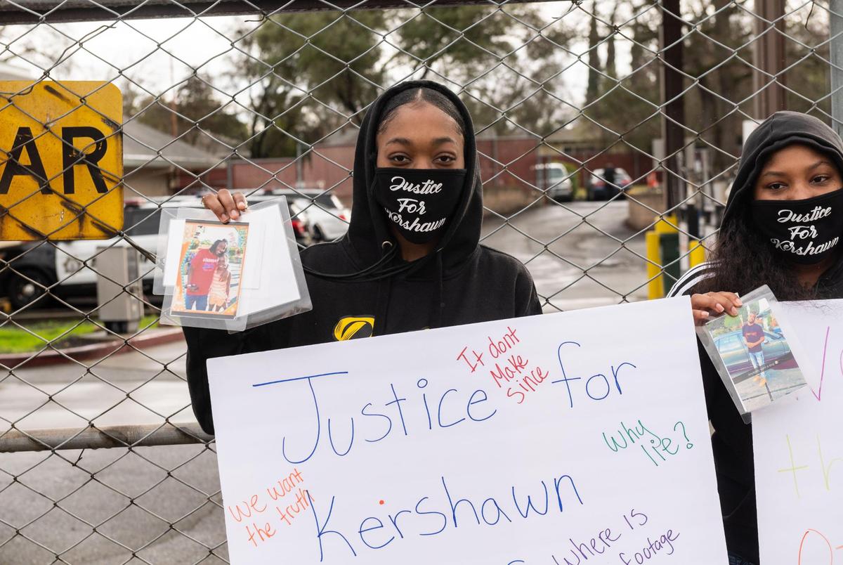 Kershawn Geyger’s sister, Patience Geiger, left, and cousin, Destiney Johnson, hold signs calling for answers regarding Geyger death in an incident with Sacramento County Sheriff’s gang investigators in Carmichael on Jan. 15, 2021. Geiger and Johnson stand at a gate outside the sheriff’s North Area substation along Garfield Avenue on Friday, Jan. 22, 2021, in Sacramento County.