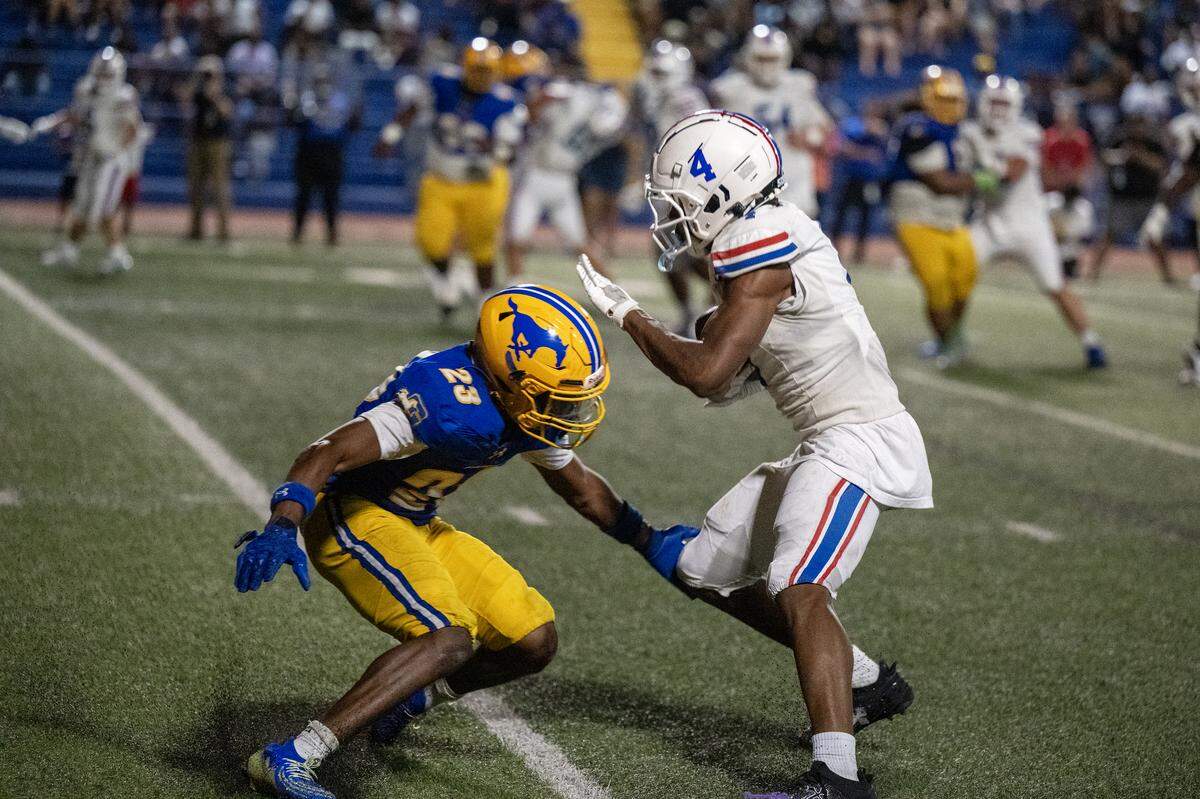The Folsom Bulldogs' Isaiah Williams (4) puts a move on a Grant Pacer defender before scoring a touchdown in Del Paso Heights in August. 