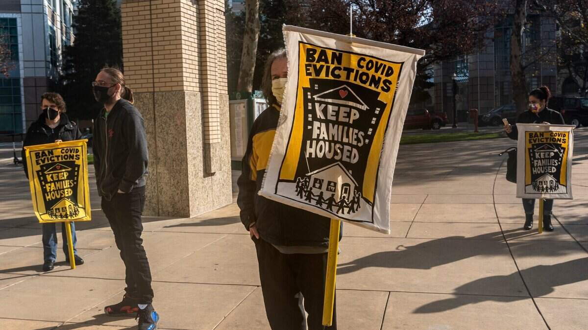 Robert Coplin, center, joins the Sacramento Eviction Defense Network at a press conference to protect tenants from eviction in front of Sacramento City Hall on Monday, Dec. 21, 2020.