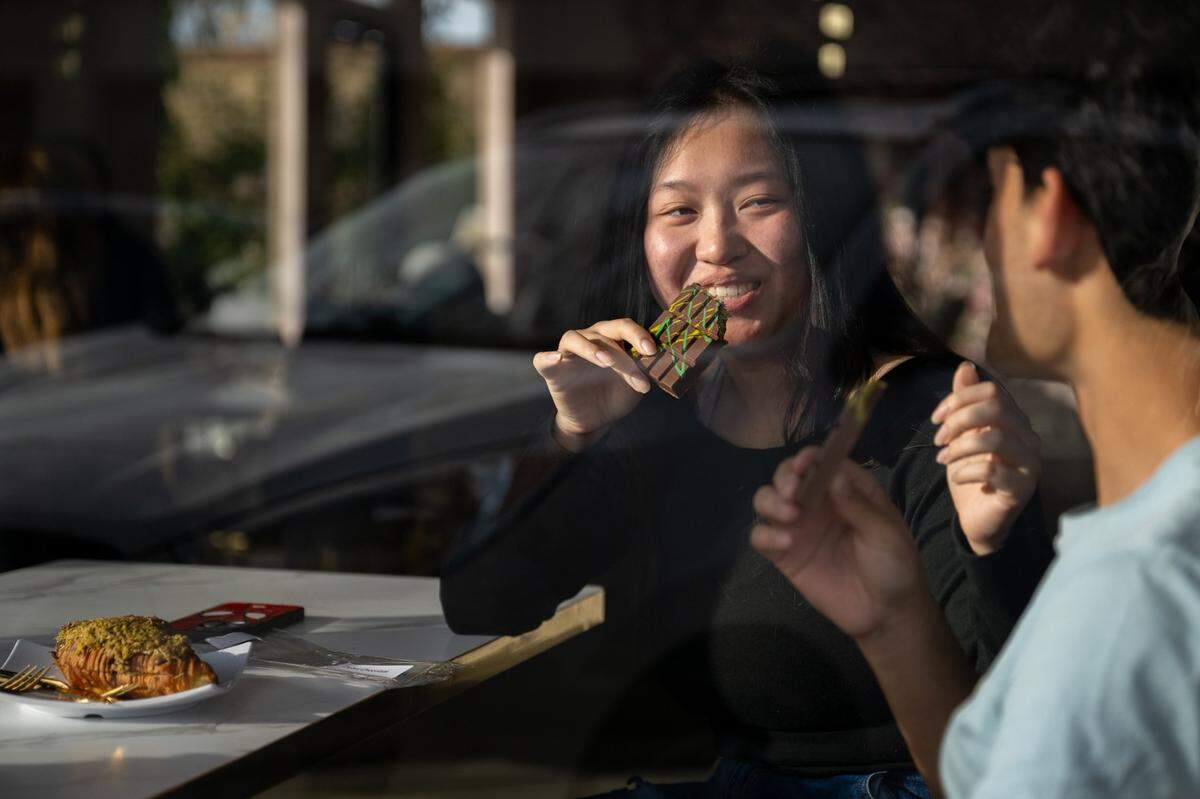 Enola Vue prepares to take a bite of Dubai chocolate with her friend Jack Dan at Nour’s Cafe on Thursday, Feb. 20, 2025, in Carmichael.