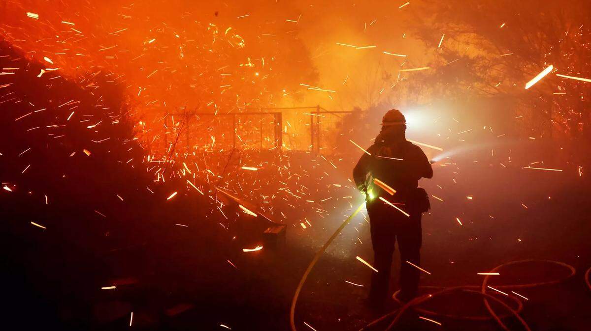 Firefighters battle the Franklin Fire next to a business along Pacific Coast Highway in Malibu in December. 