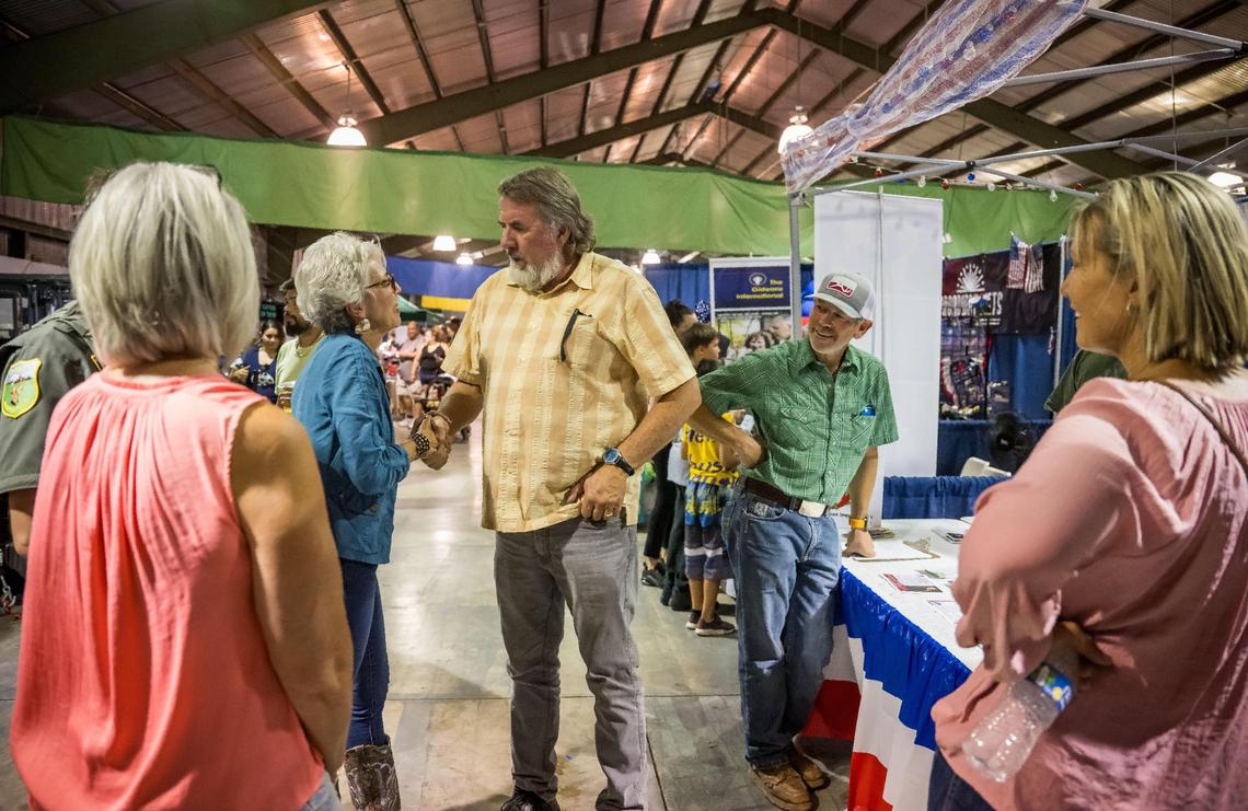 Congressman Doug LaMalfa, center, shakes hands with former Siskiyou County Supervisor Lisa Nixon as other Republicans, elected officials and supporters surround him while he visits the county Republican party’s booth at the Siskiyou Golden Fair in Yreka in 2023. 