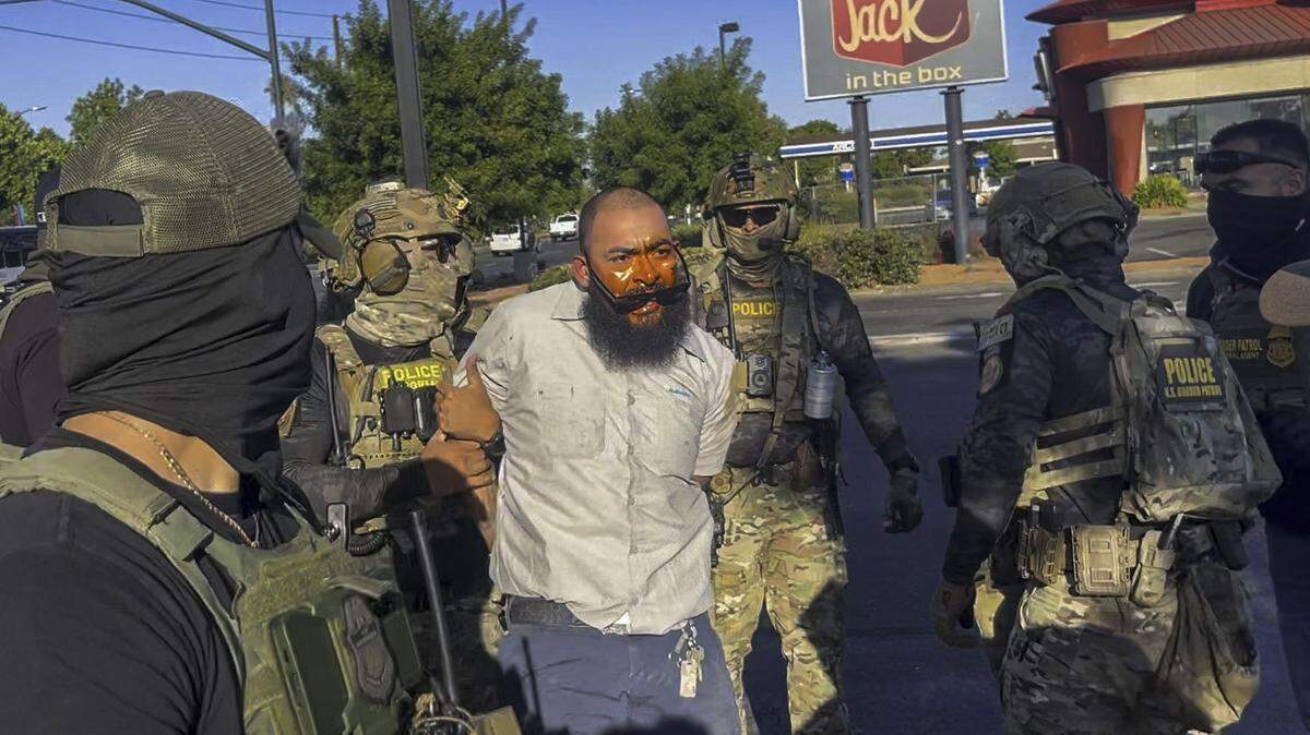 In an image from video, Jose Castillo is detained by U.S. Border Patrol officers at the Florin Road Home Depot in south Sacramento on Thursday, July 17, 2025. Castillo’s wife Andrea said he is a U.S. citizen who was recording the actions of the masked federal agents.