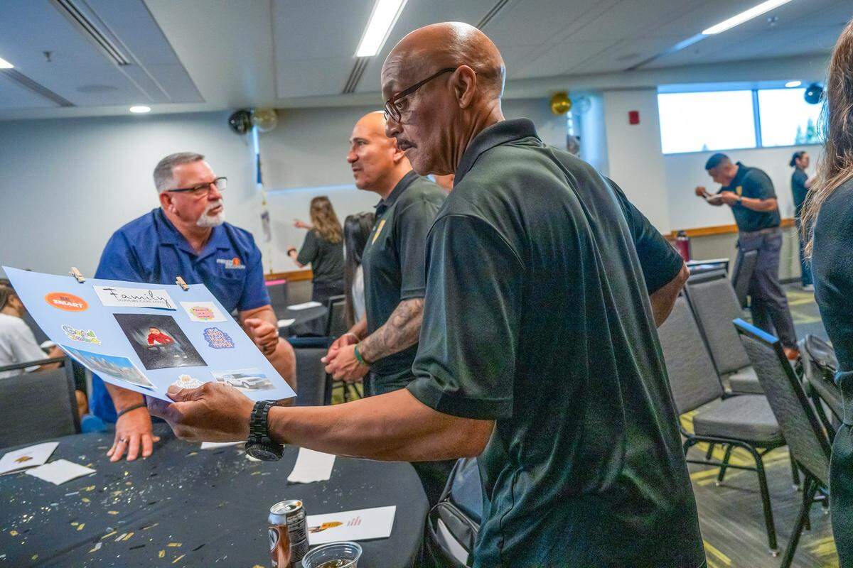 David King makes his way back to his seat with the vision board he completed in class during the Reintegration Academy graduation held at Sacramento State on May 9. Students were asked to create vision boards to help visualize their future. King emphasized that spending time with his grandson was a priority, and included a picture of him on his board.
