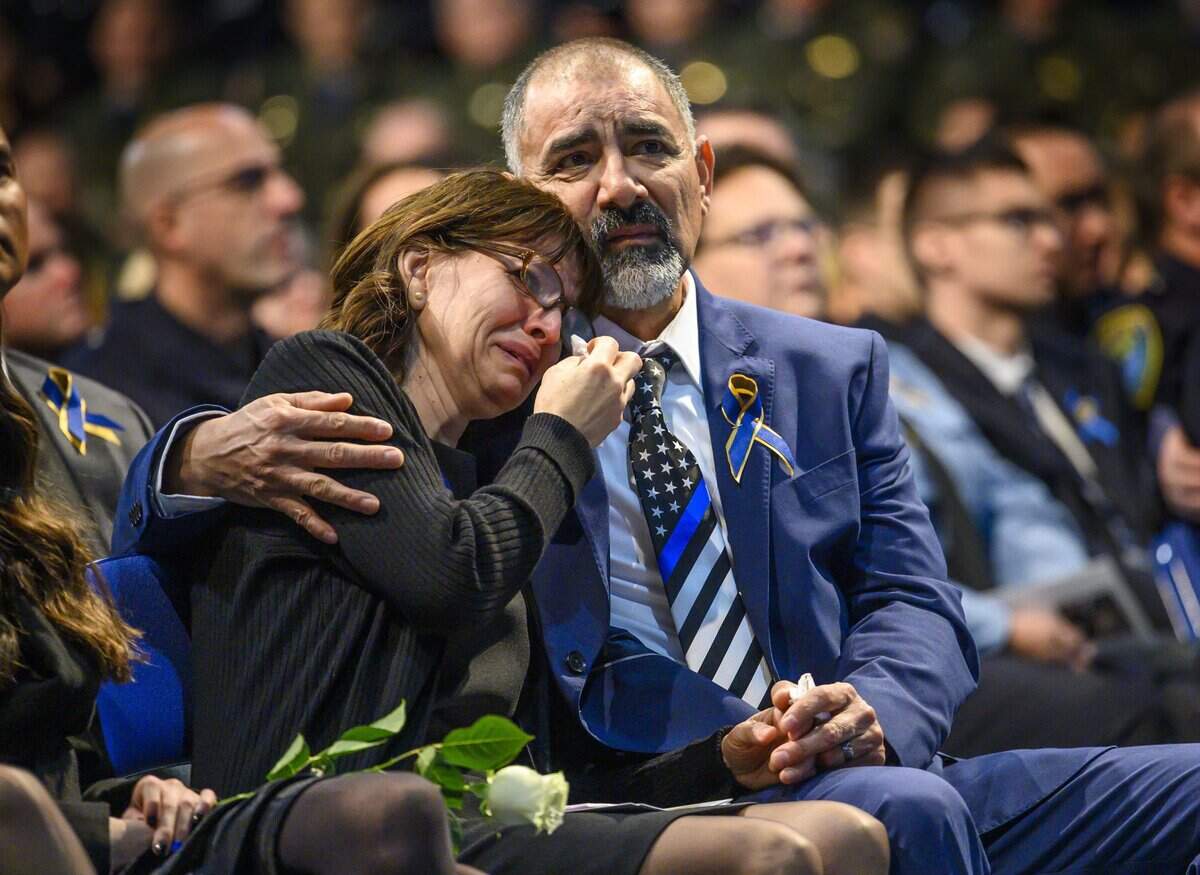 Lupe and Merced Corona, parents of Davis police officer Natalie Corona, comfort each other as thousands gathered to mourn the fallen officer at The Pavilion at UC Davis on Friday, Jan. 18, 2019.