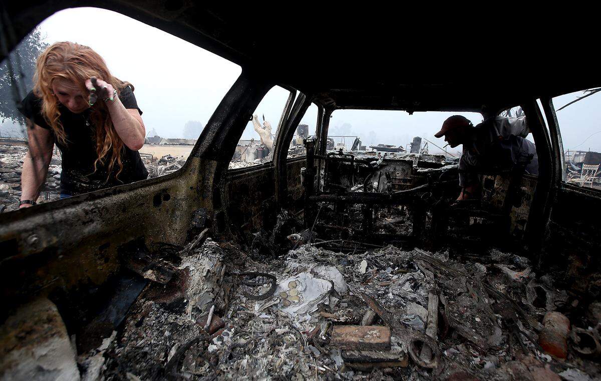 Sherri Marchetti-Perreault and James Benton look at their destroyed car at their home along Highway 96 in Klamath River on Monday. “It happened so fast,” said Marchetti-Perreault. “We left with the clothes on our back.”