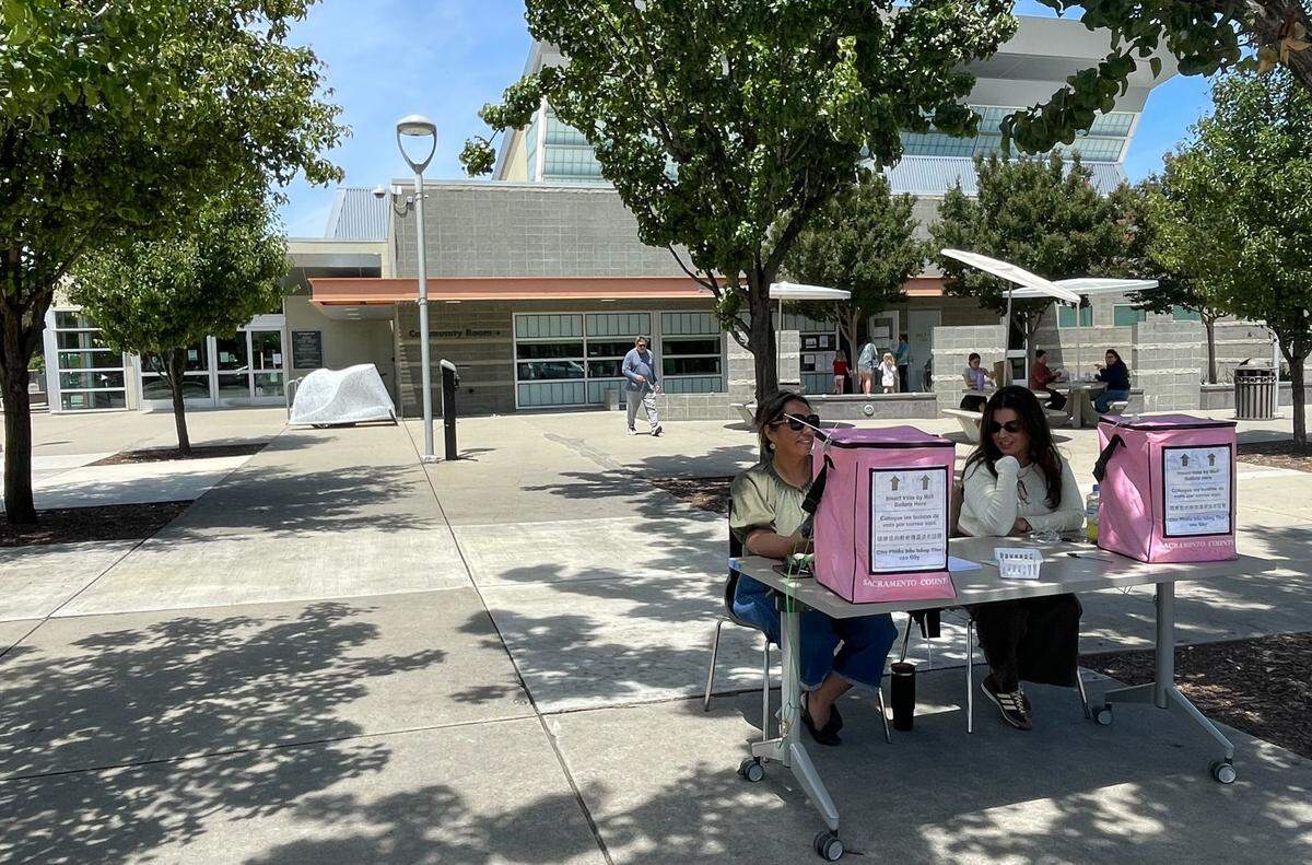 Primary election workers monitor the curbside ballot drop-off at the North Natomas library, which neighbors American River, on Tuesday, June 2, 2026.