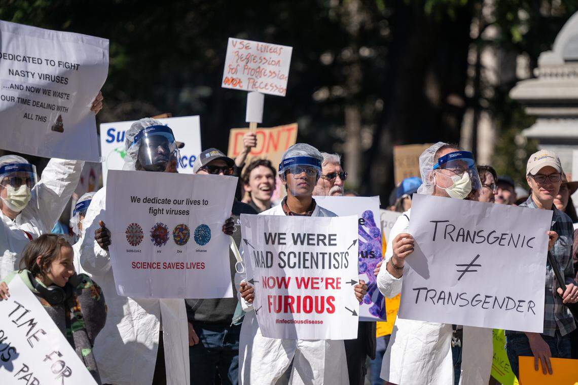 UC Davis professor Koen Van Rompay, right, stands with his students Okuny Awow, left, and Shrivees Vigayan during a Stand Up for Science protest at the State Capitol on Friday. 