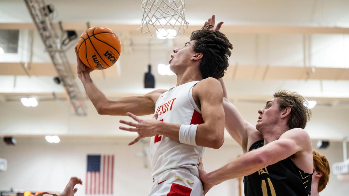 Jesuit Marauder guard/forward Andrej Stojakovic (2) goes up for a reverse layup for two points as Rio Americano Raider guard Luke Mason (11) defends from behind during the third quarter of the high school boys basketball game Friday, Dec. 16, 2022, at Jesuit High School in Carmichael.