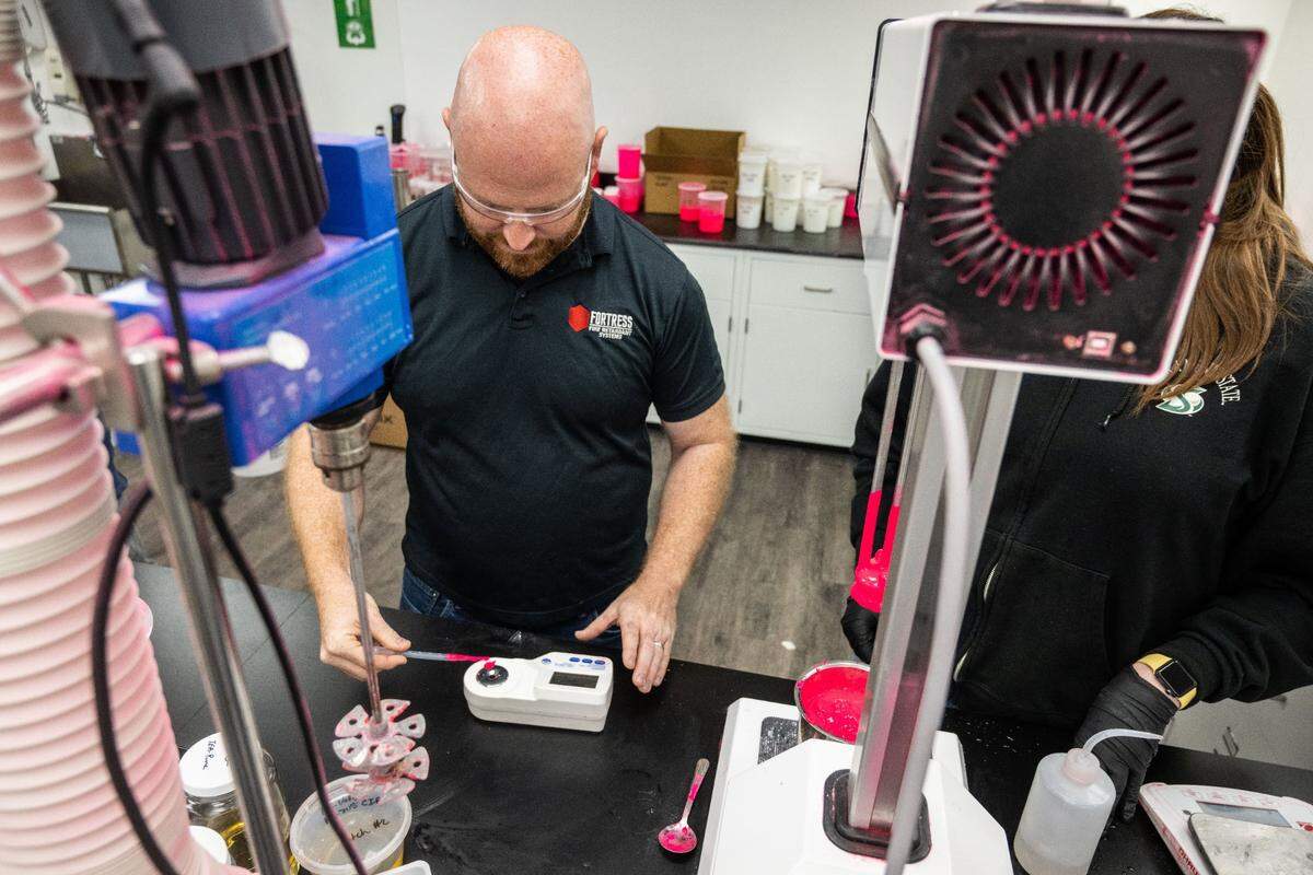 Michael White, director of research and development, tests a sample of retardant made with magnesium chloride earlier this month.