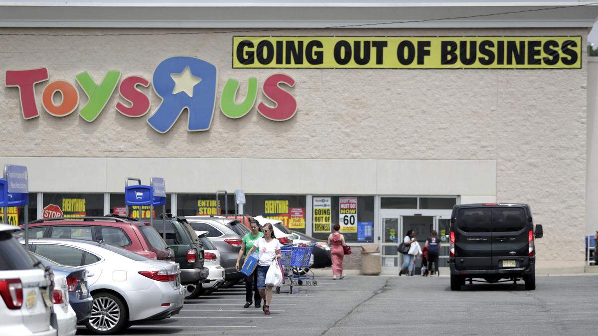 Customers walk back to their vehicles after shopping at a Toys R Us store, Friday, June 1, 2018, in Totowa, N.J. Politicians, including U.S. Sen. Bob Menendez and Sen. Cory Booker, held a news conference at the Totowa location to voice their concerns after it was announced that employees will not get severance packages once the stores are closed following the bankruptcy of the company. (AP Photo/Julio Cortez)