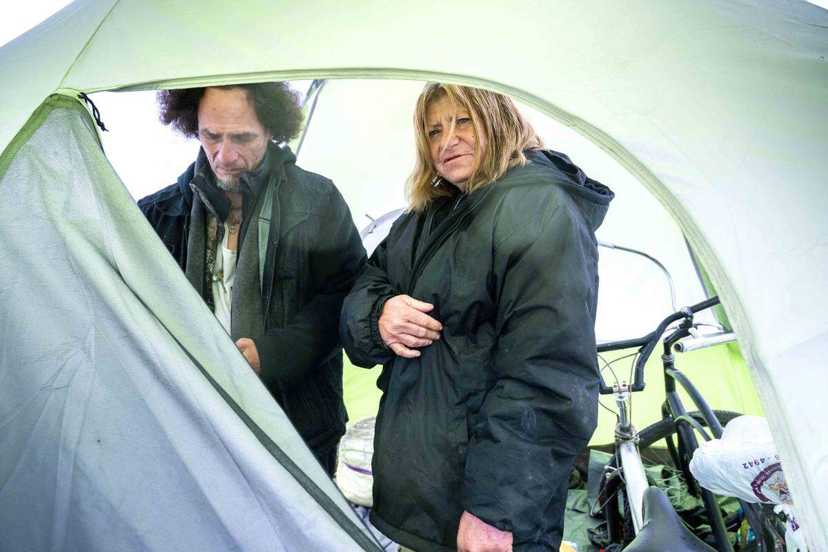 Spanky Arteaga and his girlfriend Debbie Kafka take shelter from the rain in a tent last month just outside the vacant tiny home village that was constructed last summer by Sacramento County.