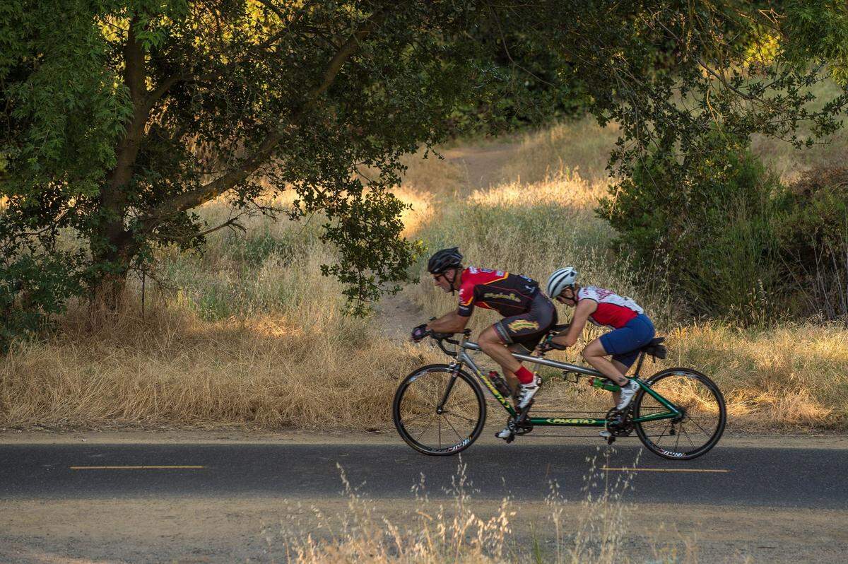 Cyclists ride a tandem bike on the American River Parkway in Arden Arcade in 2017. The popular amenity runs along the community’s southern edge.