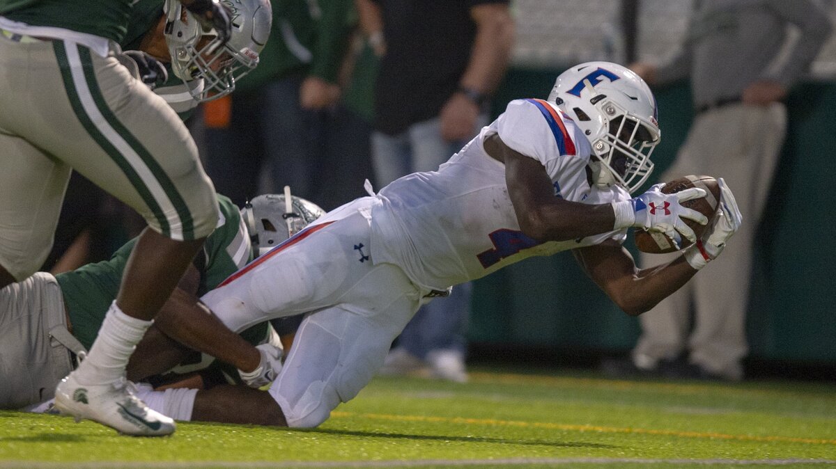 Folsom Bulldogs’ Daniyel Ngata touches his knee to the turf short of the goal line before losing the football in the second quarter against De La Salle on Friday in Concord.