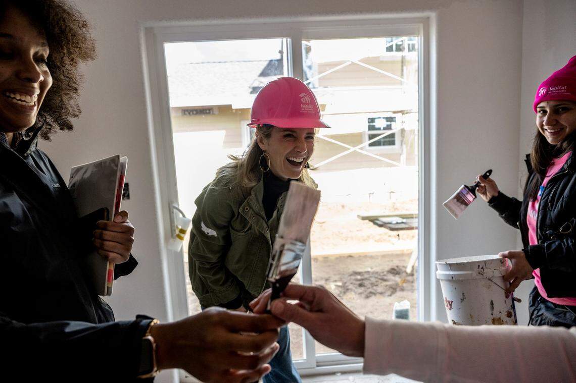 First Partner Jennifer Siebel Newsom, center, laughs as her paint brush is taken away while helping Monique Lujan, right, paint her home in Sacramento during an event with Habitat for Humanity in celebration of International Women’s Day on Wednesday. Lujan and her two children will move into the home she acquired through Habitat for Humanity this fall. The California Commission on the Status of Girls is sponsoring a month-long event that brings women together to address the housing crisis affecting many families in the greater Sacramento region.