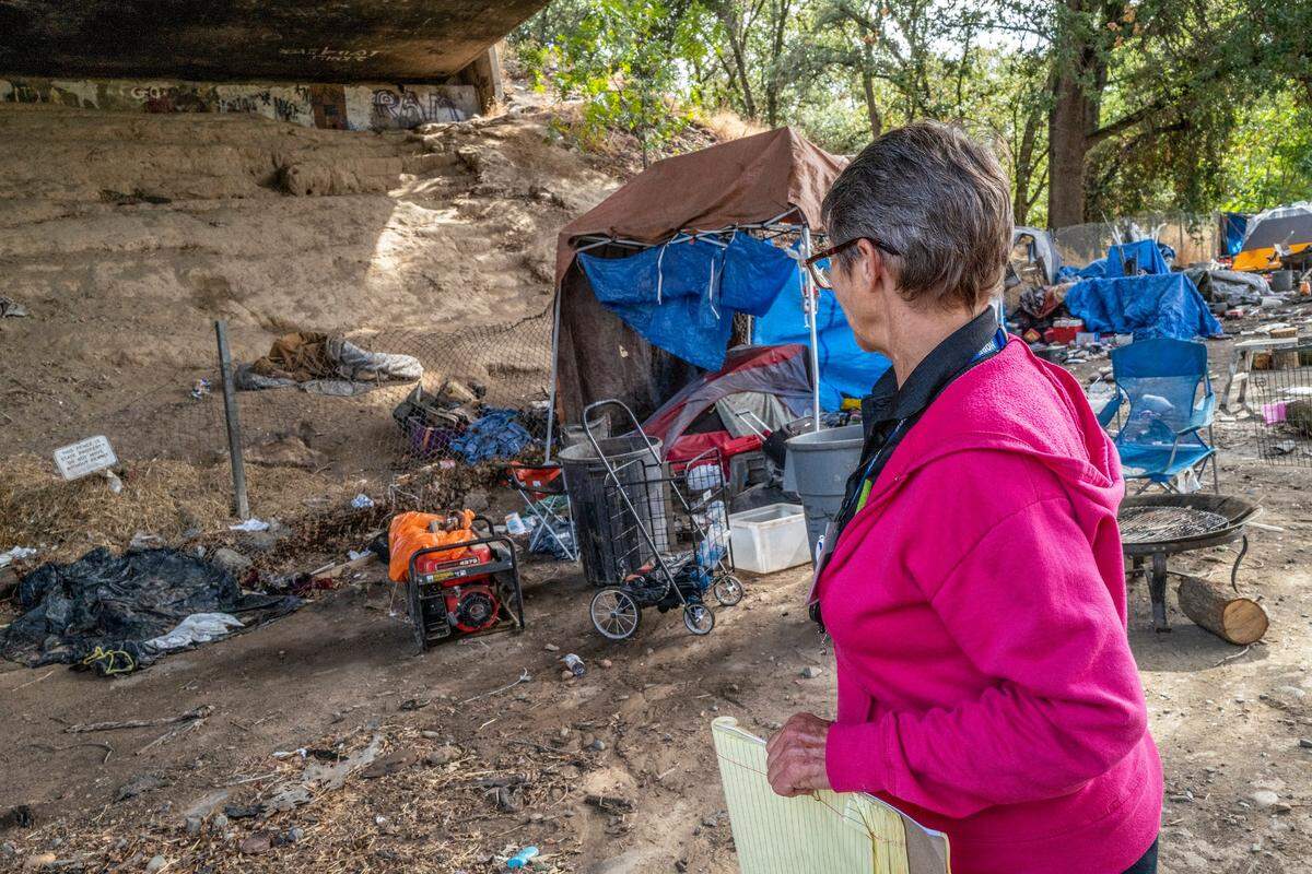 Tracey Knickerbocker looks up toward a staircase she dug underneath the 12th Street bridge when she was homeless and camped there. She said the street name for the encampment remains “Gray Skull.”