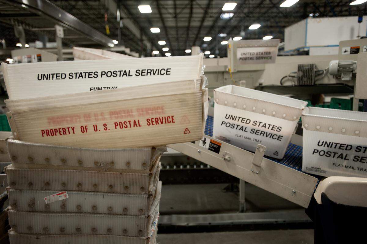 Plastic bins are stacked at the West Sacramento regional distribution center, post office for use to move the daily mail.