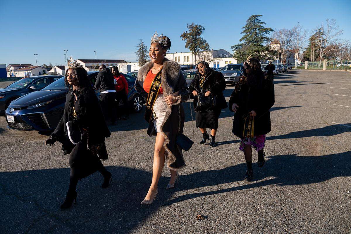Aaliyah Adams, Miss Black Sacramento 2020, center, walks with Miss Black Teen Sacramento 2020 Bethany Onic, left, before the #ReclaimMLK Day car caravan in celebration of Martin Luther King Jr. Day at Grant High School in Sacramento on Monday.