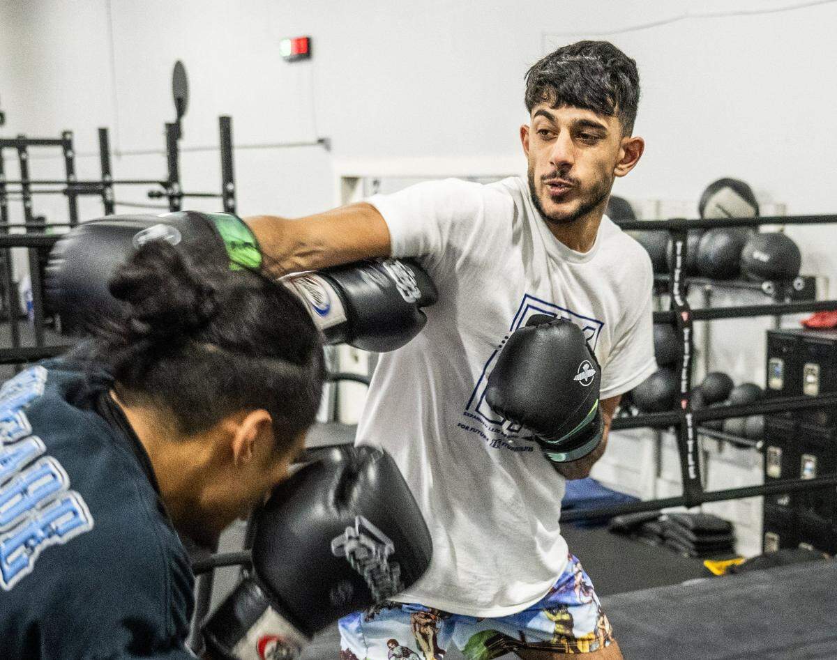 Sacramento State student Sahir Mahadevan, right, trains with fellow student Genesis Tibule on Sunday at Urijah Faber’s Ultimate Fitness gym in East Sacramento. The university plans to revive boxing as a club sport as a way to attract a new and different student demographic.