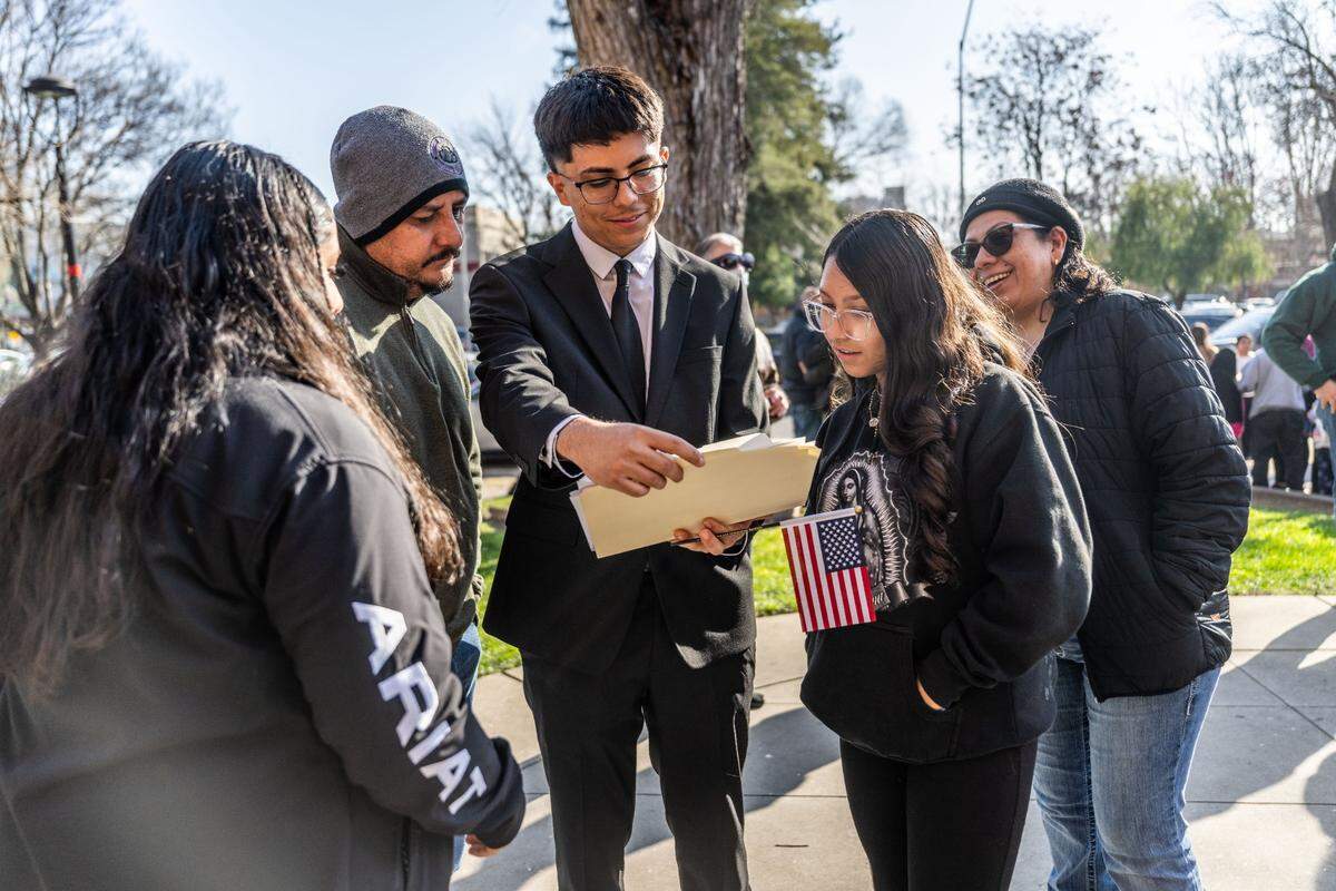 Lathrop resident Hector Arreola shares his naturalization certificate with his family as more than 800 people took the oath to become U.S. citizens on Wednesday, Jan. 29, 2025. Arreola, of Jalisco, Mexico, is the first in his family to get his citizenship and his parents and sisters hope to follow in his path.