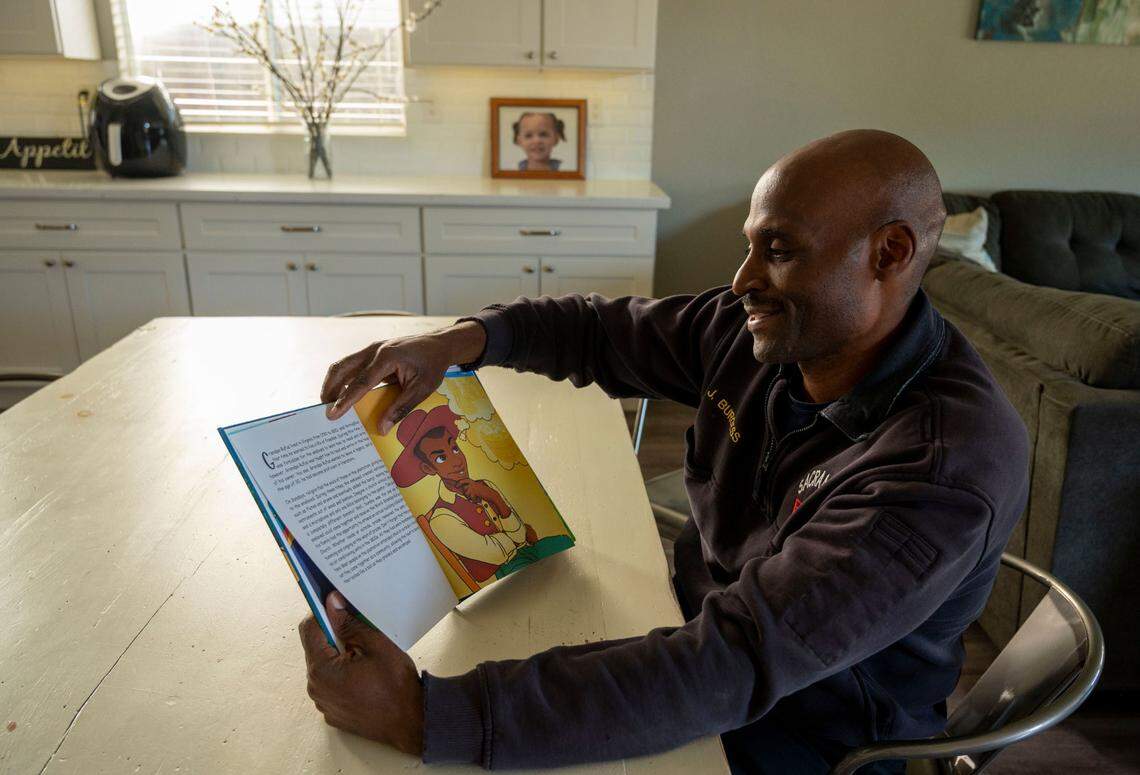 Jonathan Burgess looks at his children’s book “Gold Rush: Burgess Descendants” at his home earlier this month that shows an illustration of his great-grandfather, Rufus, a former slave that rose to prominence in early-California.