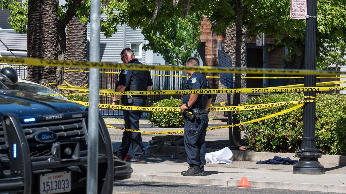 Sacramento police officers on Saturday, May 20, 2023, work near evidence at a cordoned off area at 28th and Q streets, across from Winn Park, following an officer-involved shooting in midtown. City Council on Tuesday approved funding for 12 new jobs to improve oversight into the city’s police and fire departments.