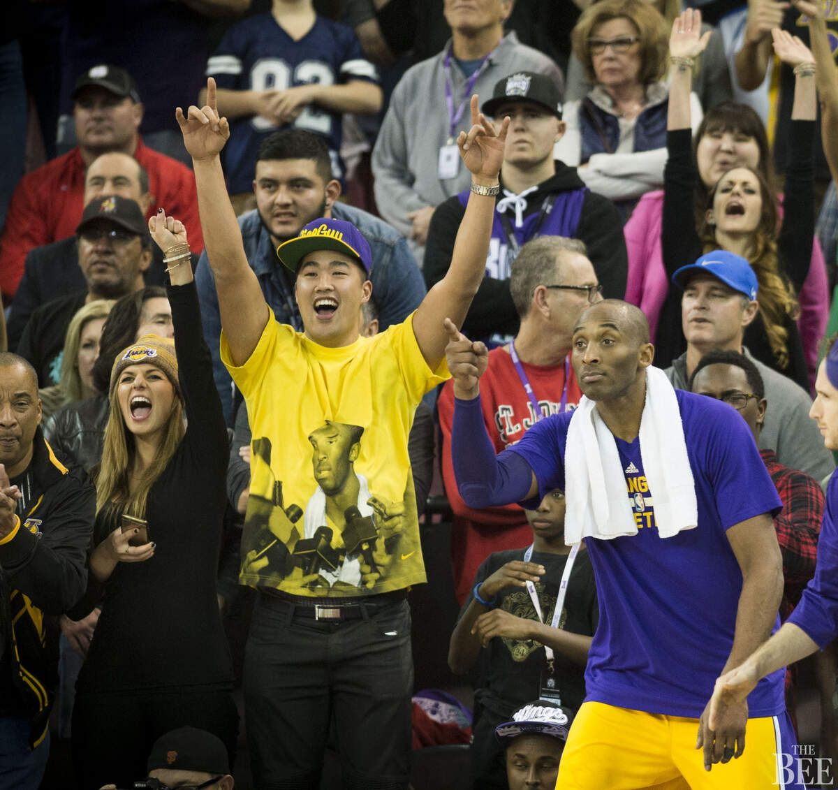 Los Angeles Lakers forward Kobe Bryant (24) joins fans in congratulating teammates as they take the lead against the Sacramento Kings in the fourth quarter.
