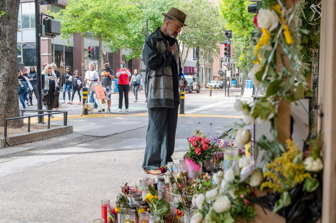 Jackie Henderson stops at the memorial of the six people killed during the mass shooting April 3 during the march for Communities Against Gun Violence on Sunday, one week after the shooting in downtown Sacramento. Henderson’s cousin Sergio Harris, 38, of North Highlands, was killed during the shooting.