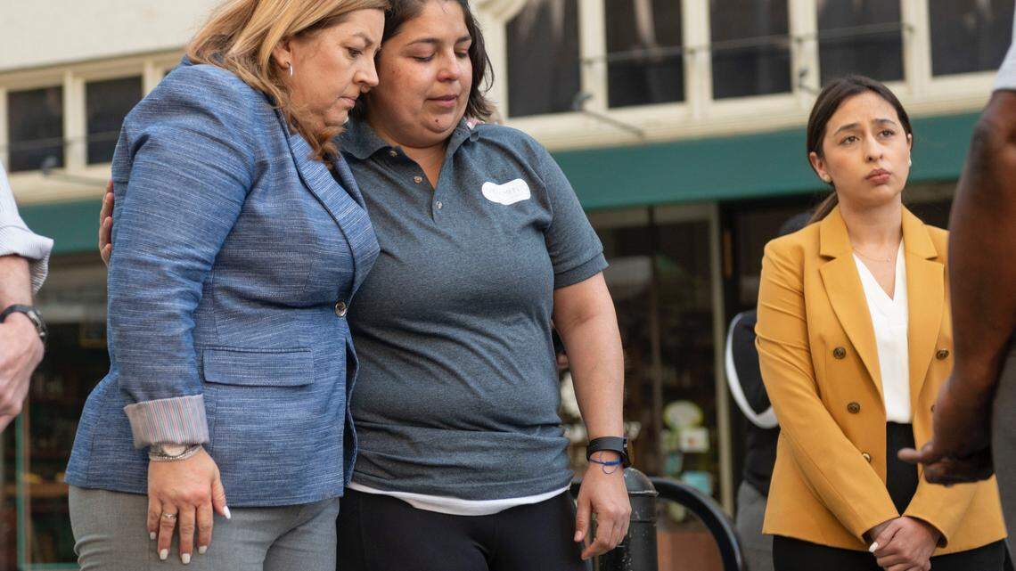 Sacramento City Council members Angelique Ashby and Katie Valenzuela comfort each other during a press conference Sunday, April 3, 2022, as the mayor speaks to the media following the mass shooting in downtown Sacramento that left six people dead and 10 more wounded.
