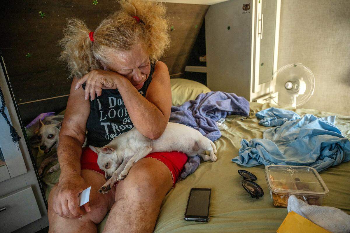 Camp Resolution resident Betty Edwards sobs alongside her two dogs on Monday from the stress of uncertainty on whether she will be evicted from the homeless encampment.