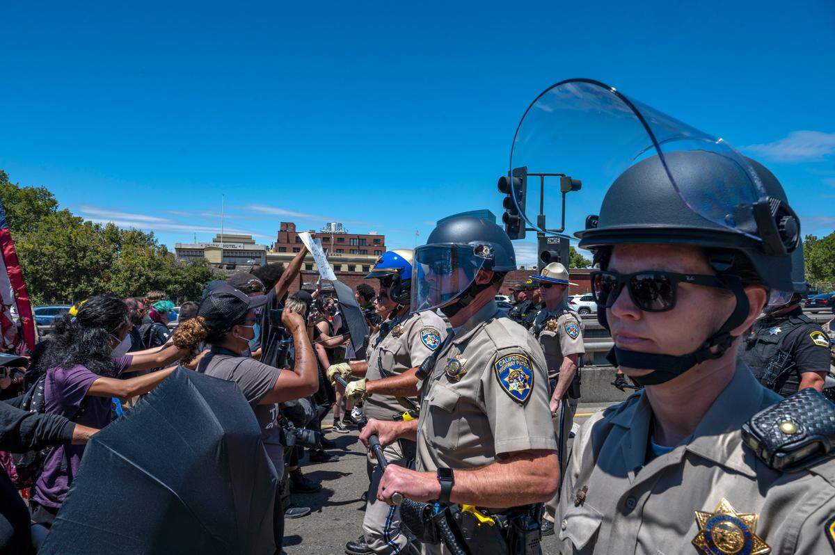 California Highway Patrol officers push back abortion rights protesters on the northbound Interstate 5 onramp in downtown Sacramento on Monday, July 4, 2022.